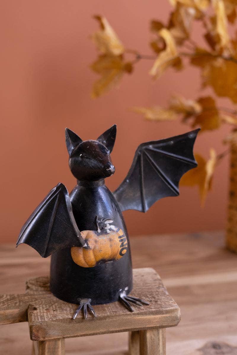 RECYCLED METAL BAT HOLDING A PUMPKIN