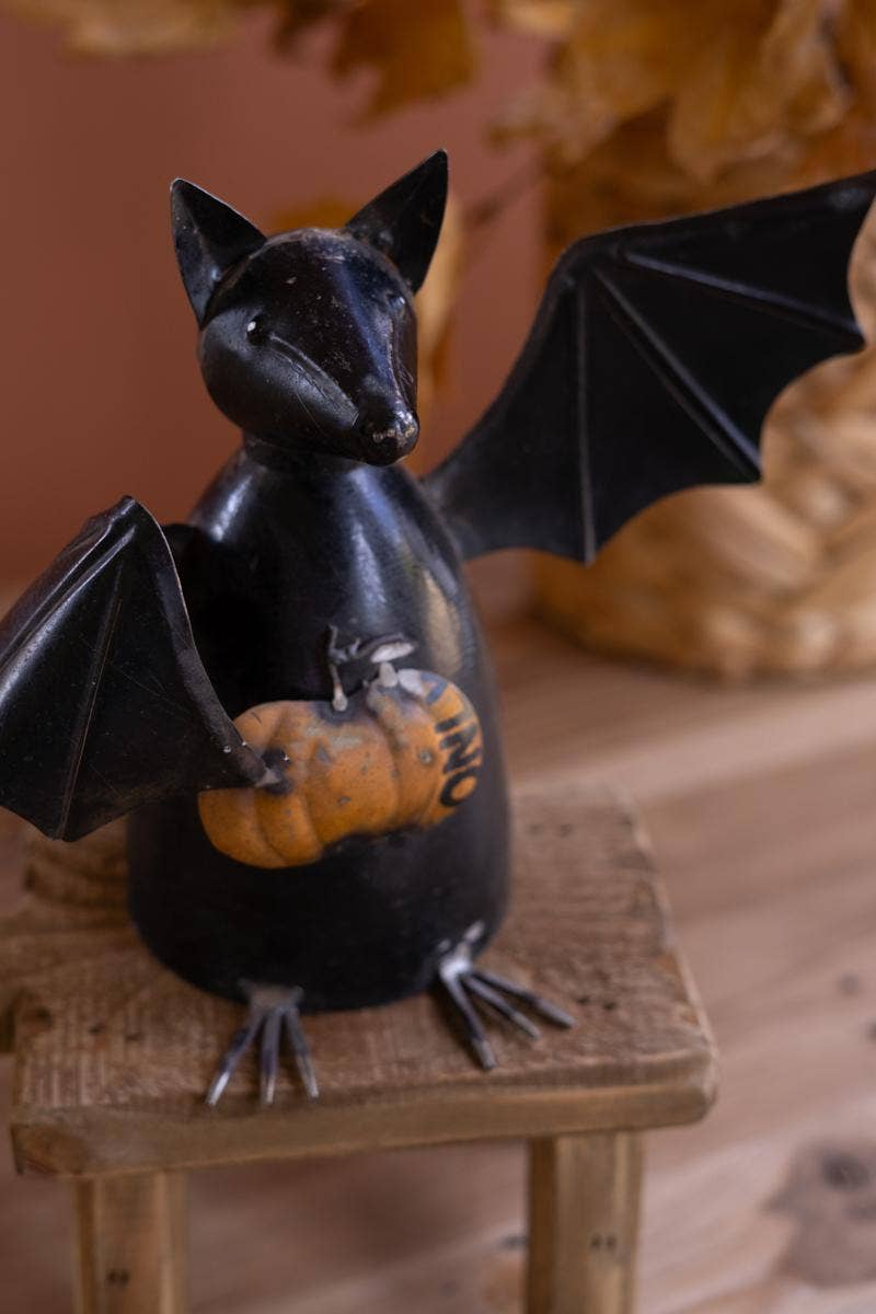 RECYCLED METAL BAT HOLDING A PUMPKIN